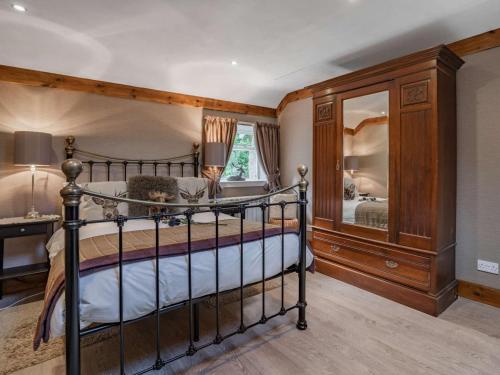Un dormitorio con una cama y un espejo grande. en 1 Bed in Callander PE173, en Strathyre