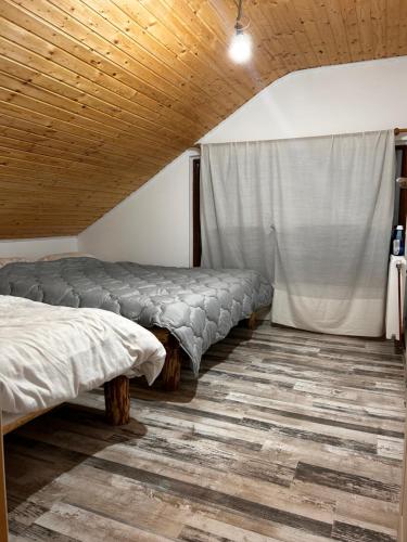 a room with two beds and a curtain at Montain Cabin Apuseni in Săgagea