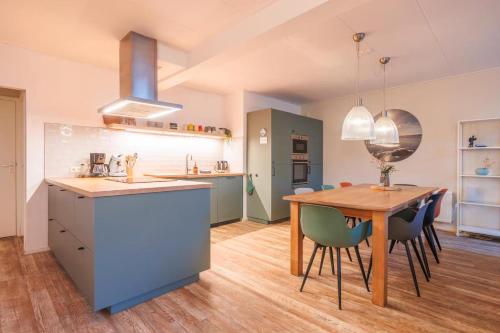 a kitchen and dining room with a wooden table and chairs at Naar Zee op Ameland in Buren
