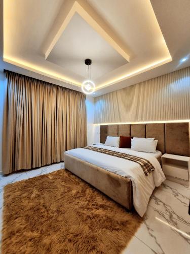 a bedroom with a large bed and a rug at Bextro Suites Magodo Phase 1 Cozy 2 Bedroom Apartment with Washing Machine in Iseri-Oke