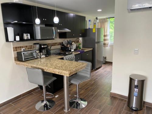 a kitchen with a counter with two chairs and a counter top at Newly remodeled apartment in Huatulco in Santa Cruz Huatulco