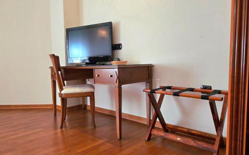 a desk with a tv on top of it with a chair at Hotel Las Moreras in León