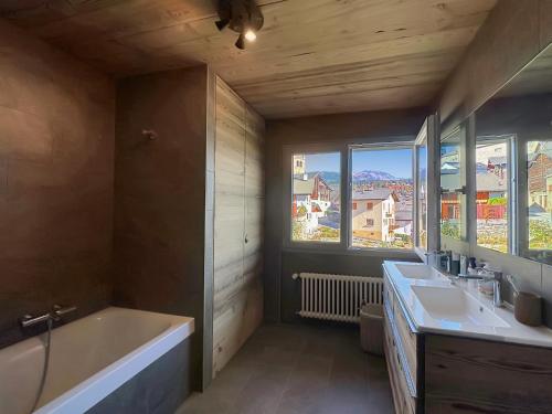 a bathroom with a tub and a sink and a bath tub at The Gathering Lodge - Crans Montana - Swiss Alps in Lens