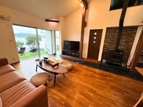 a living room with a couch and a table and a fireplace at Riverview唐津 in Karatsu
