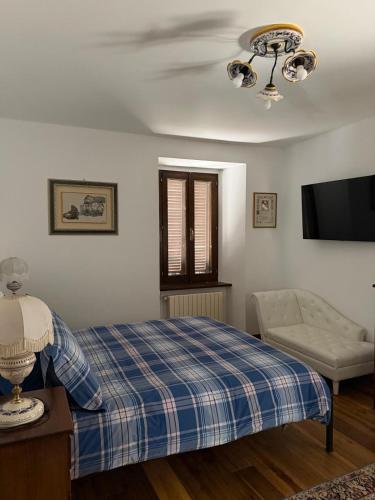 a bedroom with a bed and a couch and a television at La Terrazza di Collepino in Collepino