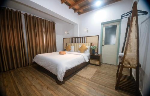 a bedroom with a bed and a wooden floor at The Living Villa in Badulla