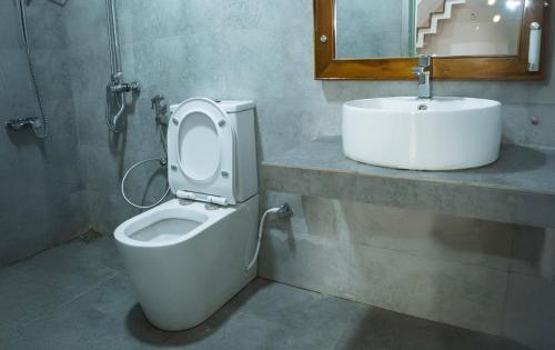 a bathroom with a toilet and a sink at The Living Villa in Badulla