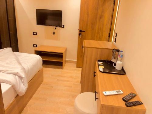 a hotel room with a bed and a desk with a television at Amigo de Las pirámides in Cairo
