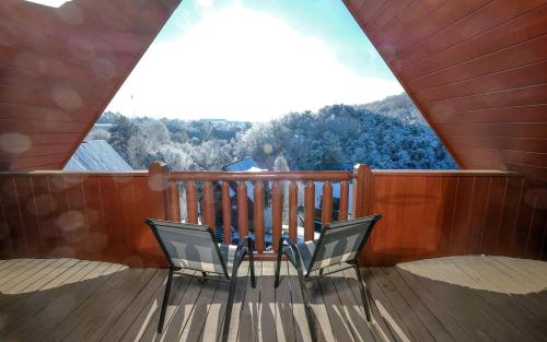 two chairs on a balcony with a view of a mountain at Above it All in Pigeon Forge