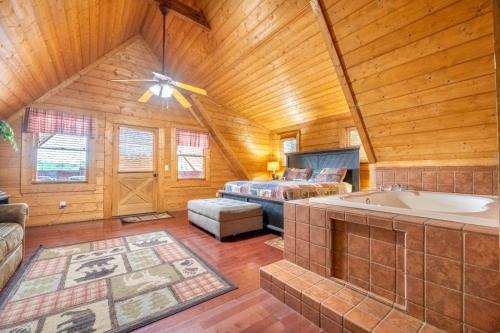 Un dormitorio con una cama y una bañera en una habitación. en Above it All, en Pigeon Forge