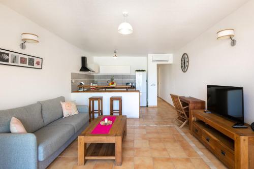 a living room with a couch and a table at SALT 6 Sur la plage de la BaieOrientale, appart 1ch in Orient Bay