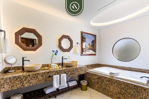 a bathroom with a sink and a tub and a mirror at 2BR House with Ocean View in Cabo in El Tule