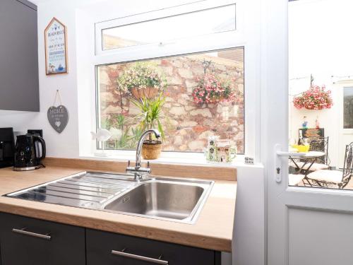 a kitchen with a sink and a window at Lilly's Cottage in Dawlish