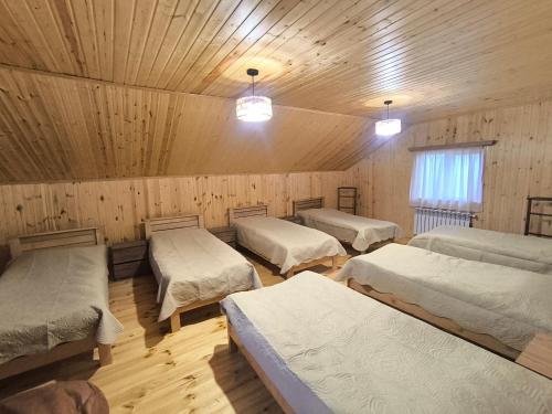 Habitación con 4 camas en una cabaña de madera en Hostel Cozy House, en Sioni