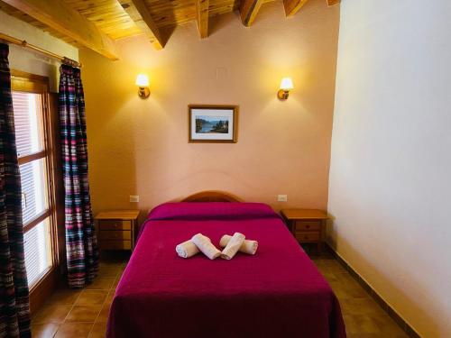 a bedroom with a red bed with two towels at Casa Forn in Ortells