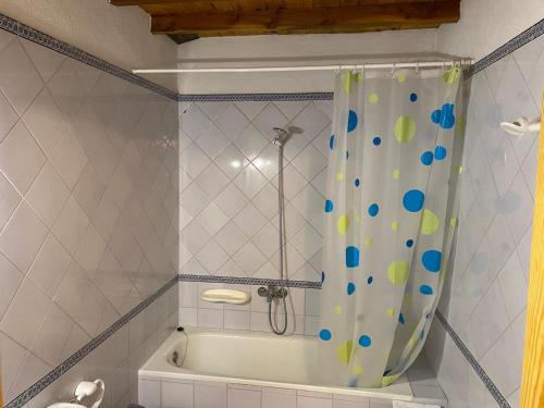 a bathroom with a bath tub with a shower curtain at Casa Forn in Ortells
