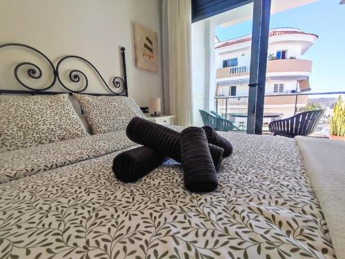 a black teddy bear laying on a bed at Korner in Adeje
