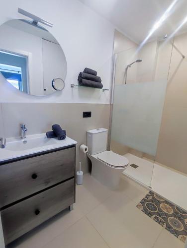 a bathroom with a toilet and a sink and a mirror at Korner in Adeje