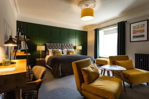 a bedroom with a bed and a table and chairs at Dacre House, Gilsland in Gilsland