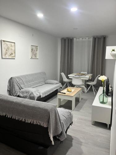 a living room with a bed and a couch at Apartamento El Rincón del Olivar III in Montoro