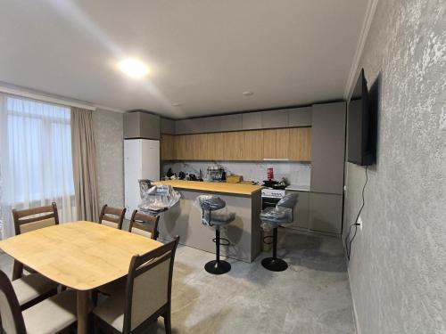 Una cocina y un comedor con mesa y sillas. en Hostel Cozy House, en Sioni