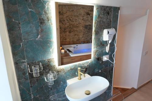 a bathroom with a sink and a mirror and a tub at Conte Luxury Rooms in Salerno