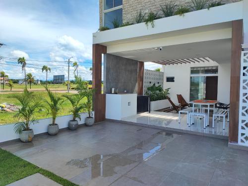 a house with a patio with a table and chairs at Arena Cielo y Mar in Santa Cruz de la Sierra