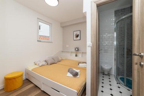 a small bedroom with a bed and a shower at Apartments Ferdo in Živogošće