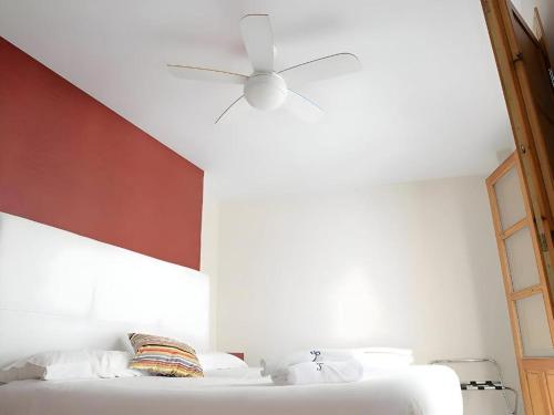 a bedroom with a white bed with a ceiling fan at Chillout 10, Granada centro in Granada