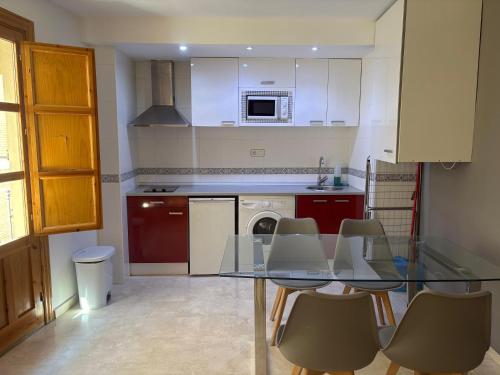a kitchen with a glass table and chairs at Chillout 10, Granada centro in Granada