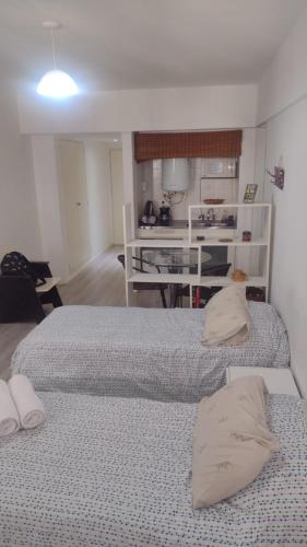 two beds sitting in a room with a kitchen at Hermoso Departamento En El Centro De Buenos Aires in Buenos Aires