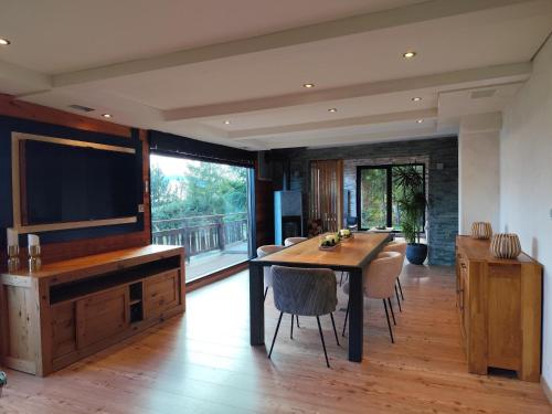 a dining room with a table and a large television at Chalet Beau-Site Anzère in Anzère