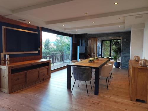 a dining room with a table and a large television at Chalet Beau-Site Anzère in Anzère