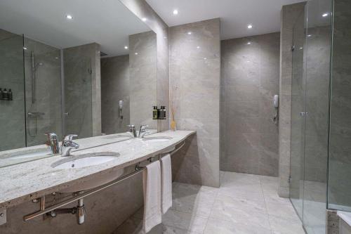 a bathroom with two sinks and a shower at Eurostars Puerta Madrid in Madrid