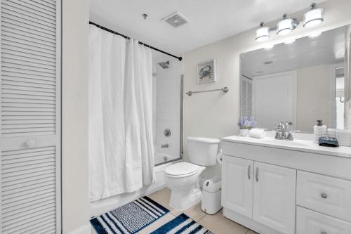 a white bathroom with a toilet and a sink at Lux condo on 25floor in Brickell in Miami