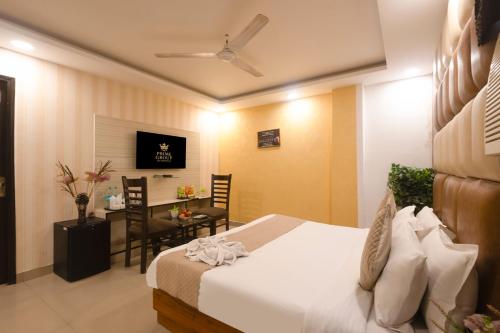 a hotel room with a bed and a table with chairs at Hotel Krone Delhi in New Delhi