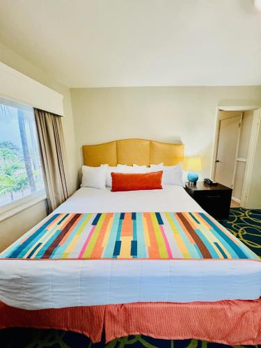 a bedroom with a large bed with a colorful blanket at Silver Seas Beach Resort in Fort Lauderdale