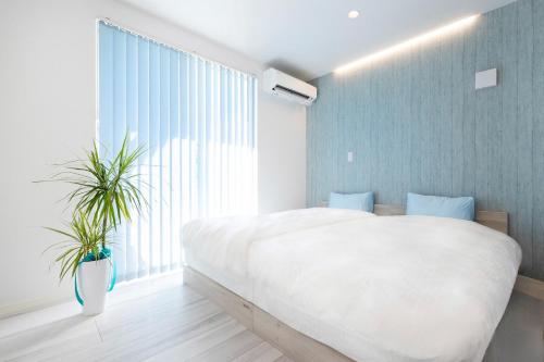 ein Schlafzimmer mit einem großen Bett und einem großen Fenster in der Unterkunft Villa Uminosora - Vacation STAY 92928v in Karatsu