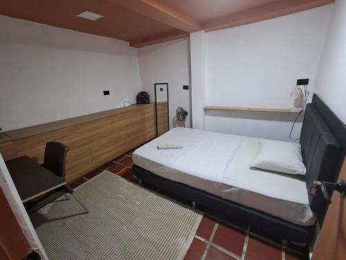 a small room with a bed and a chair at Hostal Casa Primavera in Medellín