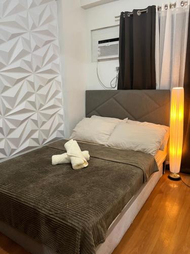 ein Bett mit einem weißen ausgestopften Tier darüber in der Unterkunft Camella Northpoint in Davao City
