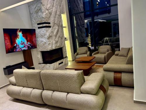 a living room with a couch and a tv at Brezovica Lux in Brezovicë