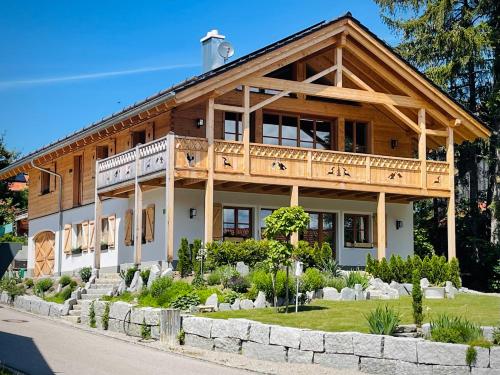 a large wooden house with a balcony at Ferienwohnung Dahoam in Bernau am Chiemsee