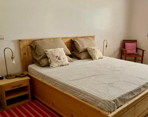a bedroom with a wooden bed with two pillows at Villa Keur Lune - Saly - SENEGAL in Saly Portudal