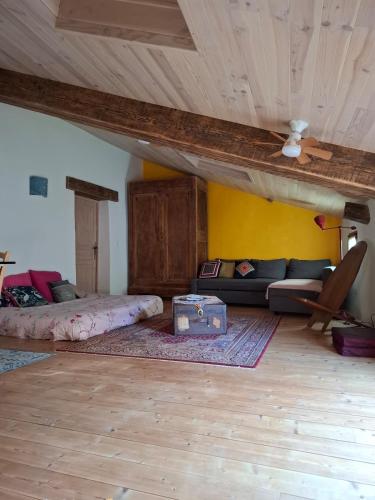 a living room with a couch and a wooden ceiling at Gîte dans La circulade - Le Pouget in Le Pouget