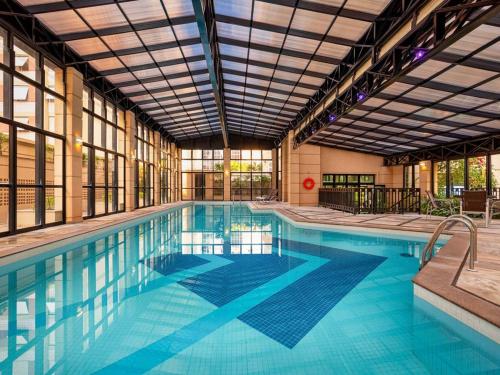 a large swimming pool with a large building at Pinheiros Luxuoso Flat em hotel 4 star in Sao Paulo