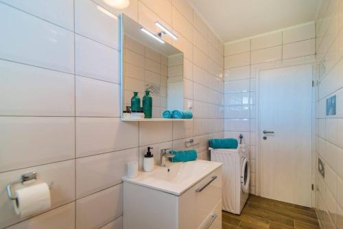 een witte badkamer met een wastafel en een spiegel bij Villa Florentina by Villa Plus in Štokovci