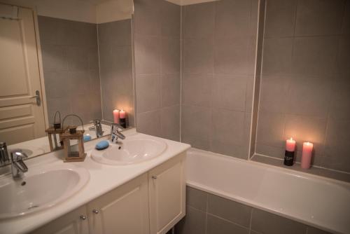 a bathroom with two sinks and two candles at Le Panoramique Rivage - Terrasse privative in Duingt