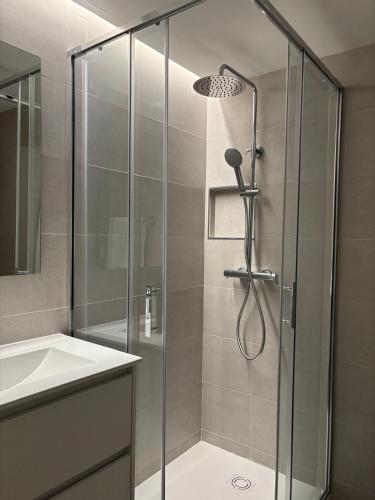 una doccia con una porta in vetro accanto a un lavandino di Apartamento Bailatús a Saragozza