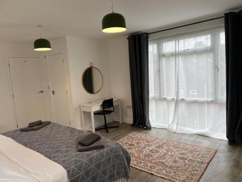 a bedroom with a bed and a window and a desk at 3 Bedroom Gatwick Free Parking Fast Wi-Fi in Horley