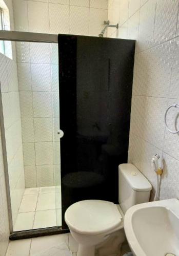 a bathroom with a shower and a toilet and a sink at Hotel Ideal in Jequié